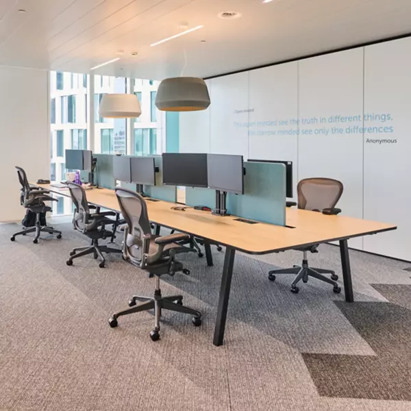 Office furniture including desks, ergonomic chairs, and acoustic panels