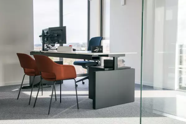 Arbeitsplatz Van Zon Pami Sitz-Steh-Schreibtisch mit ergonomischem Bürostuhl und orangefarbenen Besucherstühlen